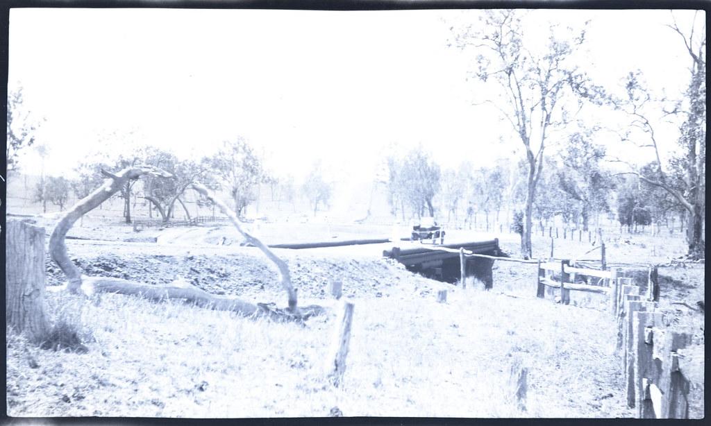 Car on wooden bridge with no guard rails and sharply bending approach road