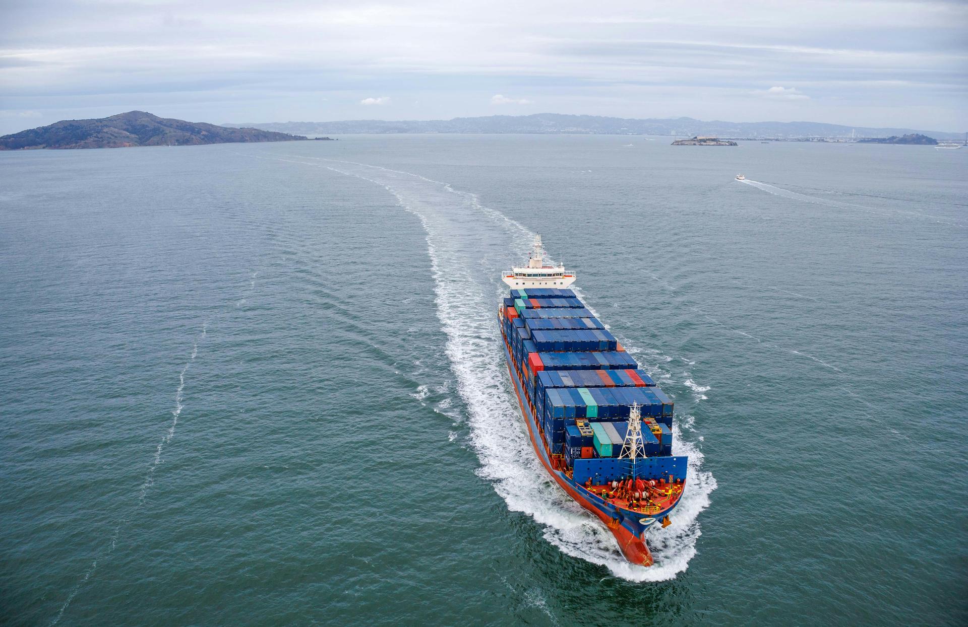 Aerial view of a large container cargo ship moving through open ocean water