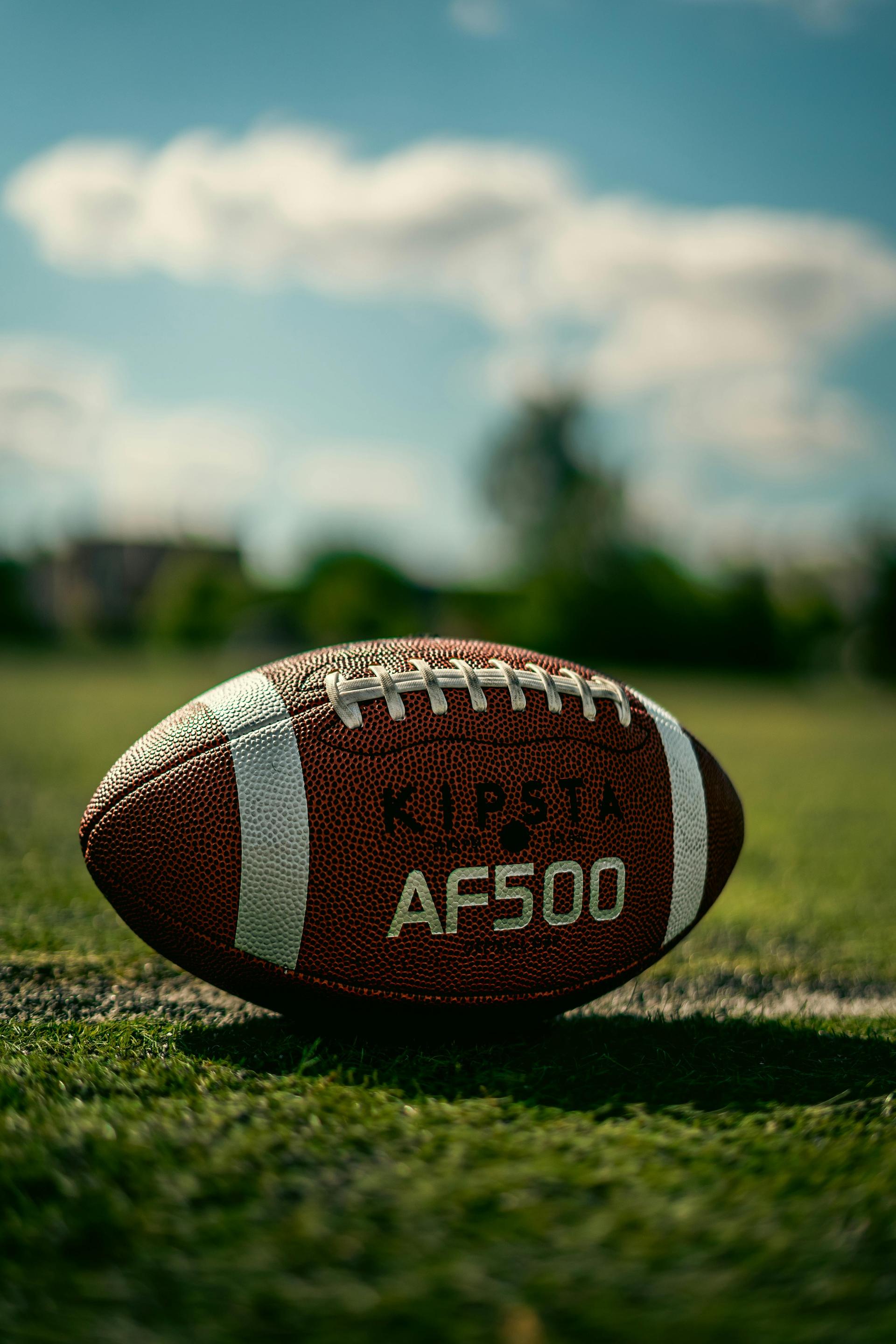 An oval rugby ball resting on a grassy field under a clear sky, a symbol of Kenya's rugby community