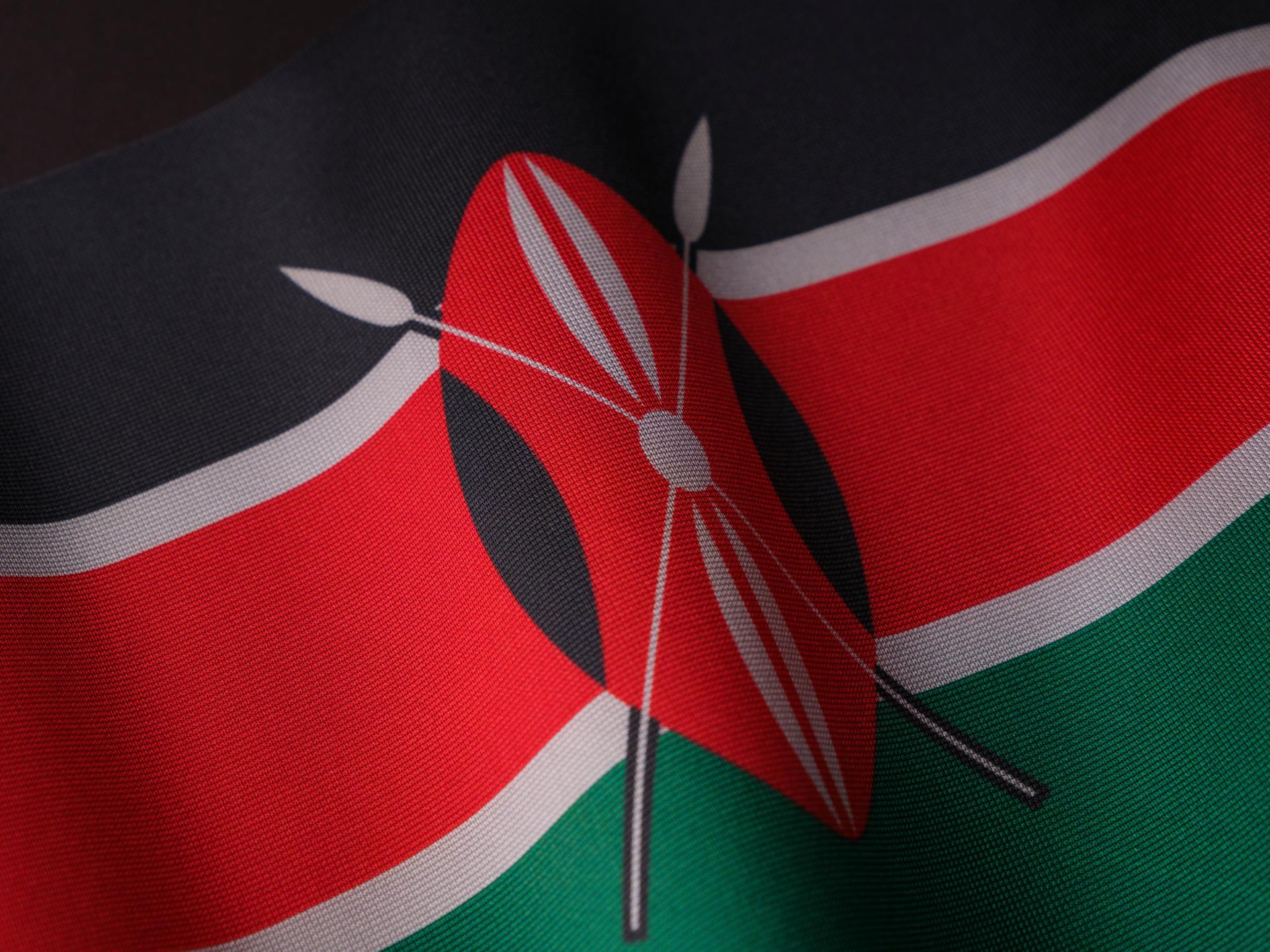 Close-up of Kenya's national flag with black, red, green and white panels rippling against a clear sky