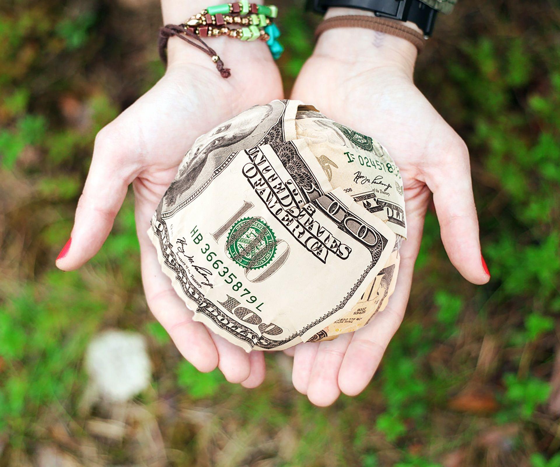 A pair of hands counting United States dollar banknotes, the currency most Kenyan diaspora remittances arrive in