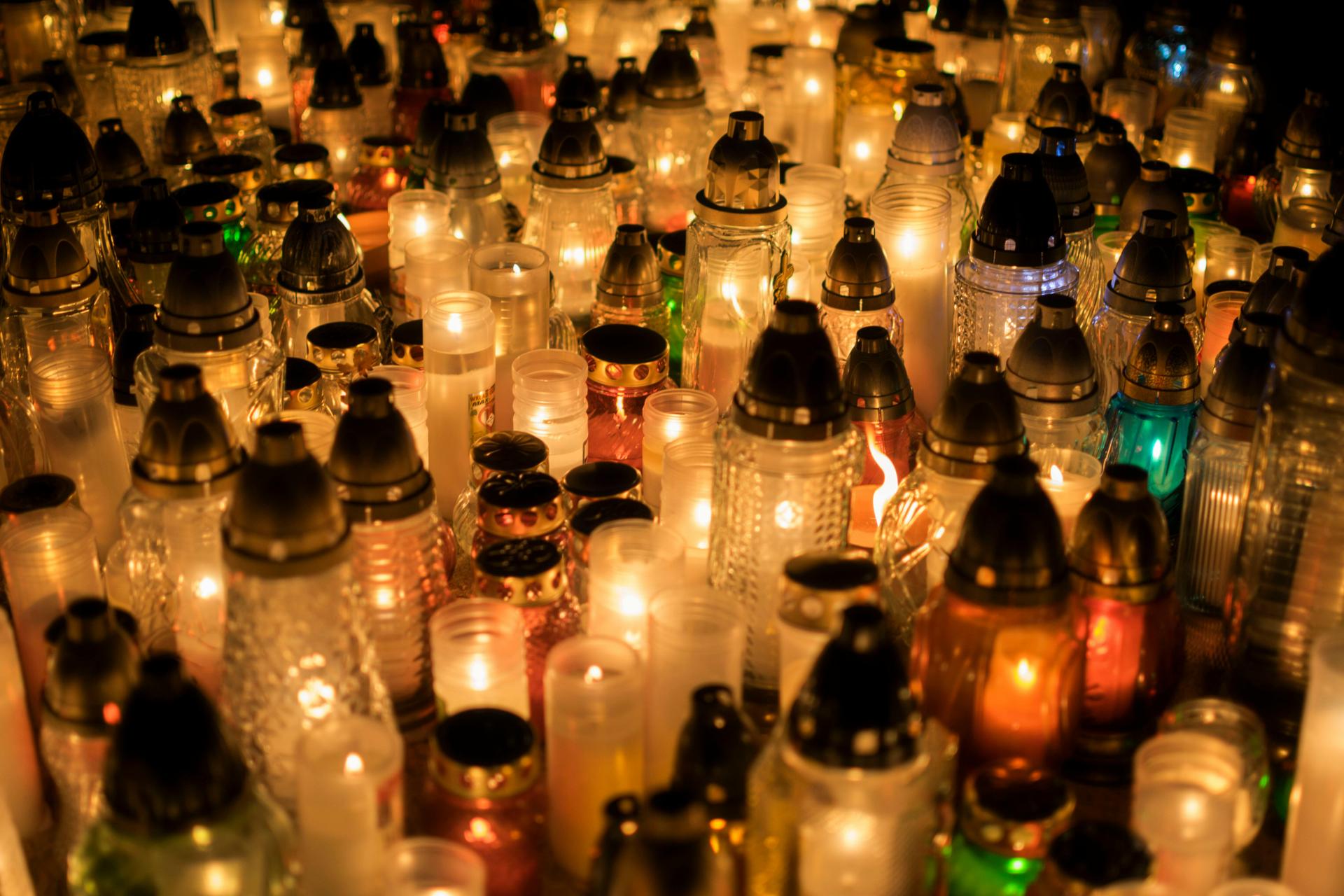 Lit memorial candles glowing on a grave at night, representing mourning, remembrance and the long Kenyan diaspora tradition of bringing loved ones home.