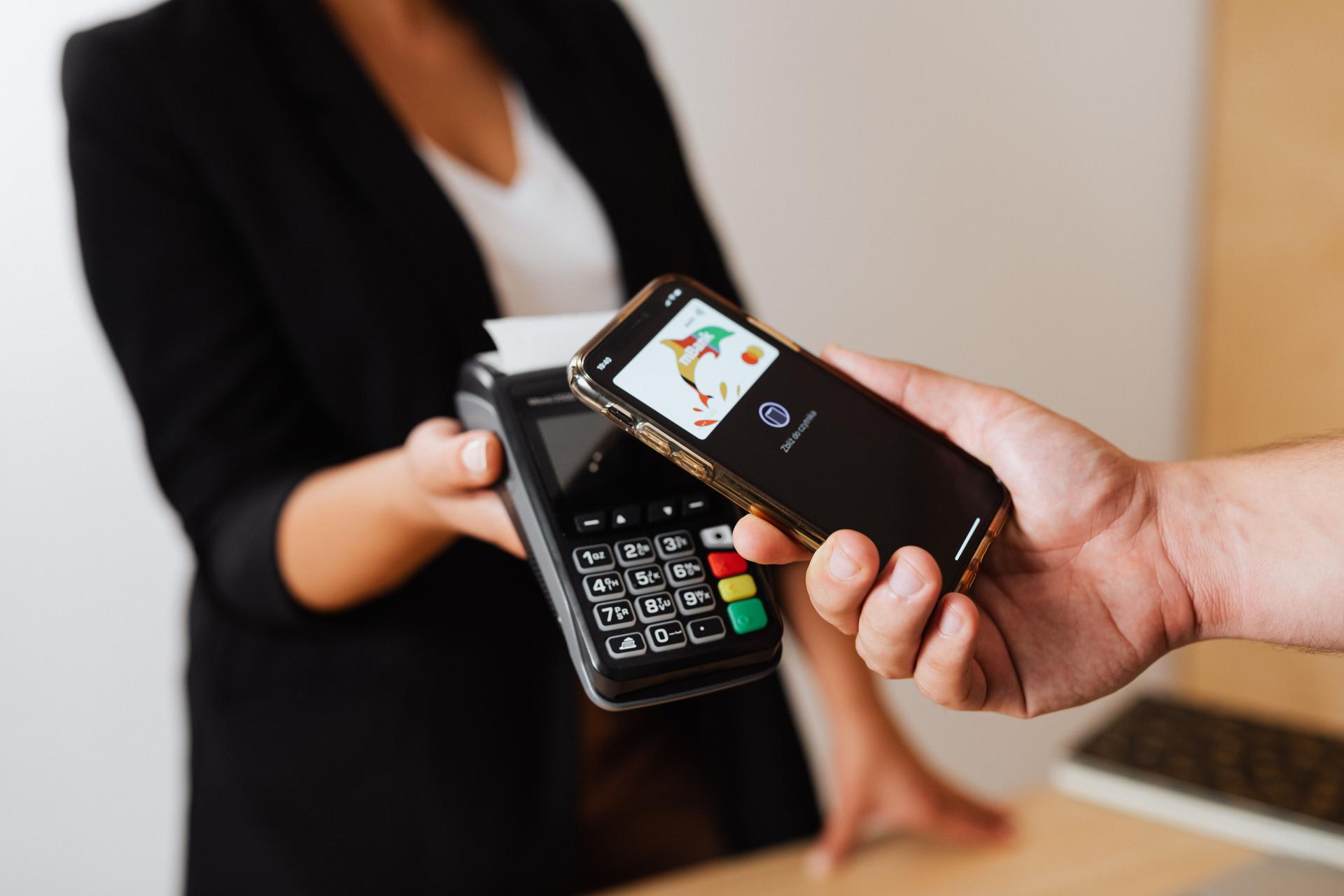 A person making a mobile-money payment on a smartphone, illustrating digital transactions and remittances.