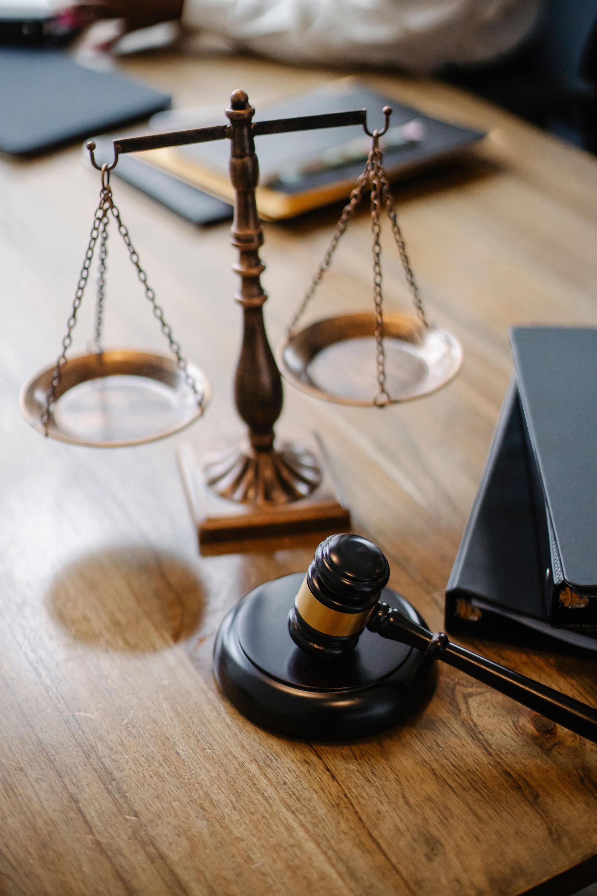 A wooden gavel and brass scales of justice on a judge's desk, symbolising a court ruling.