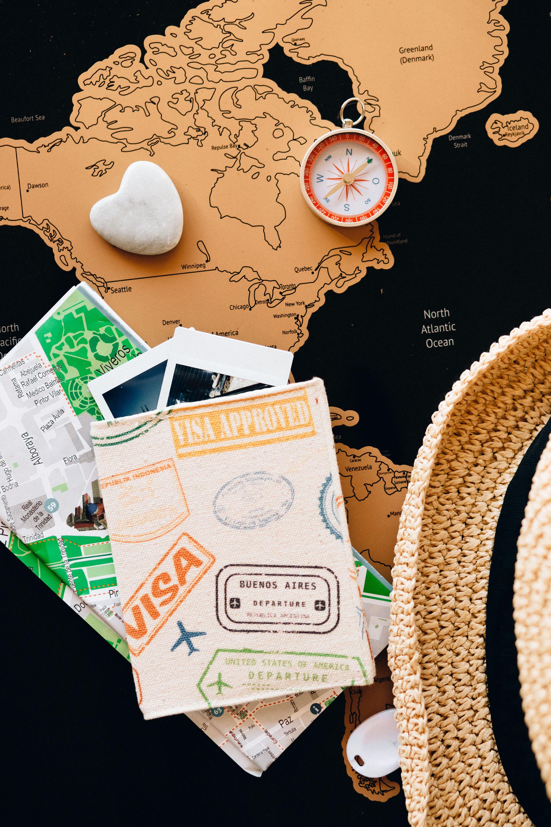 A passport and a compass resting on a world map, symbolising a professional planning to migrate abroad for work.