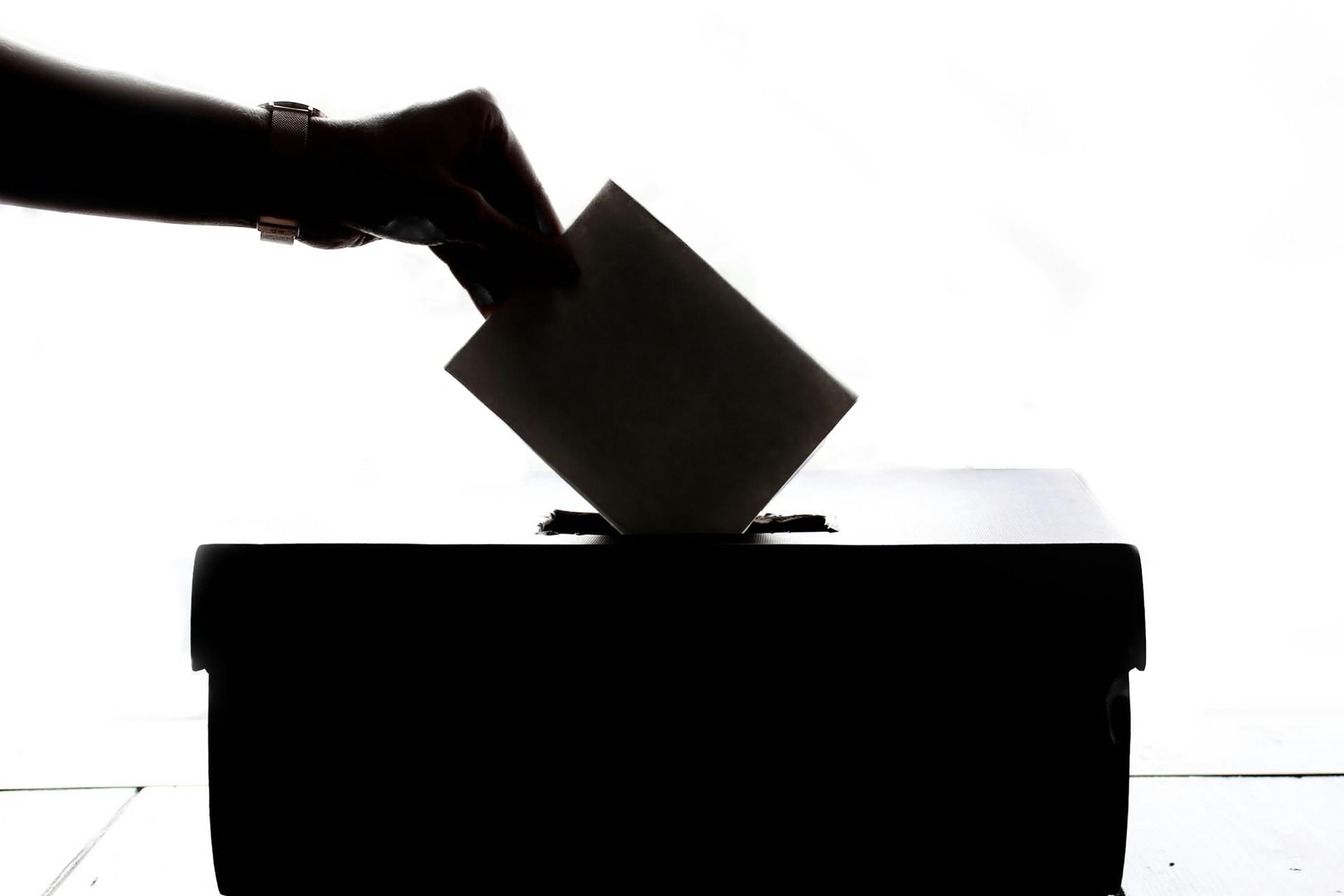 American flag with an I Voted sticker symbolising US election participation and voter registration rolls.