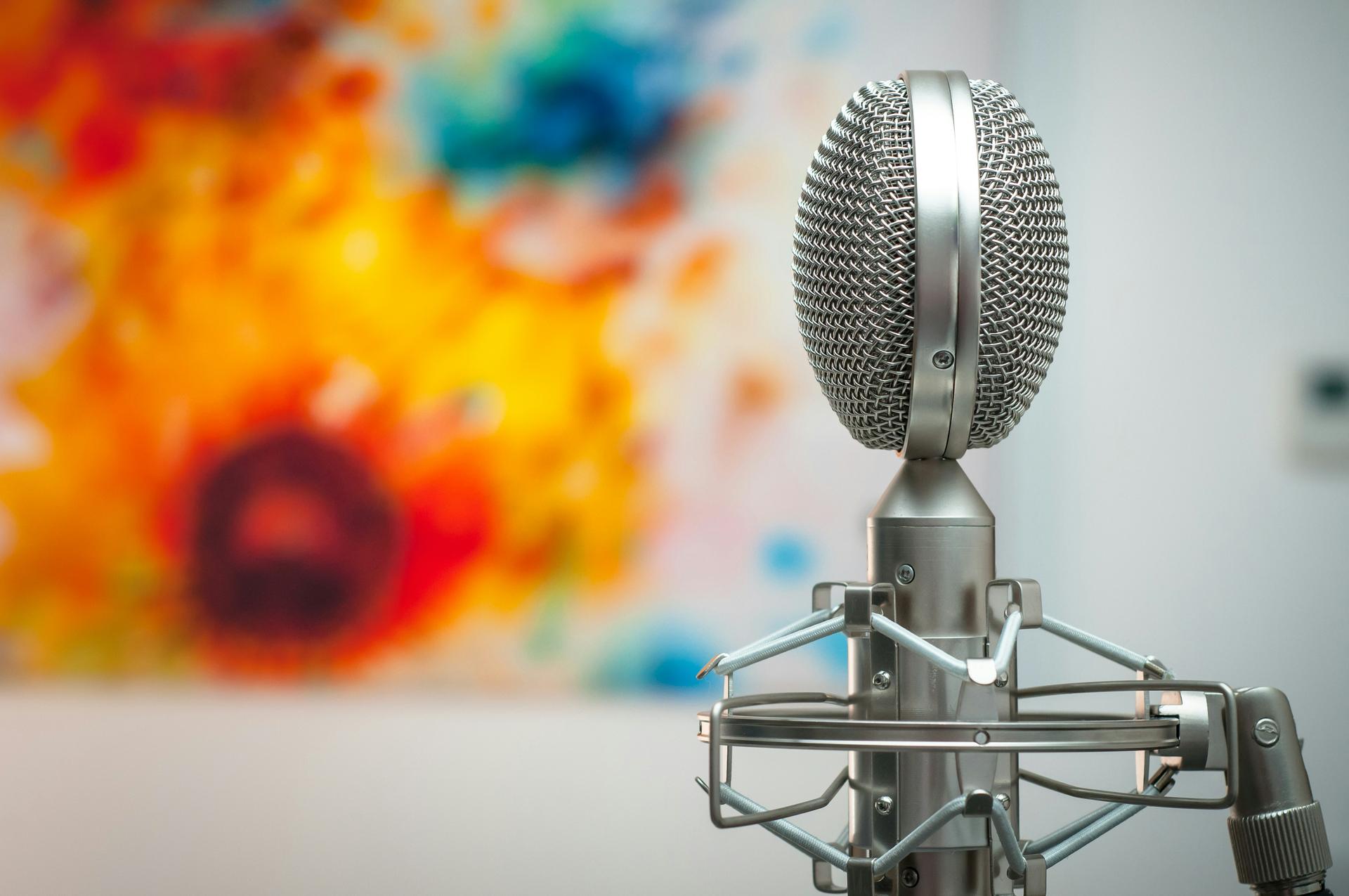 Studio microphone on a stand in a quiet recording room, evoking the daily work of journalism and broadcast reporting.