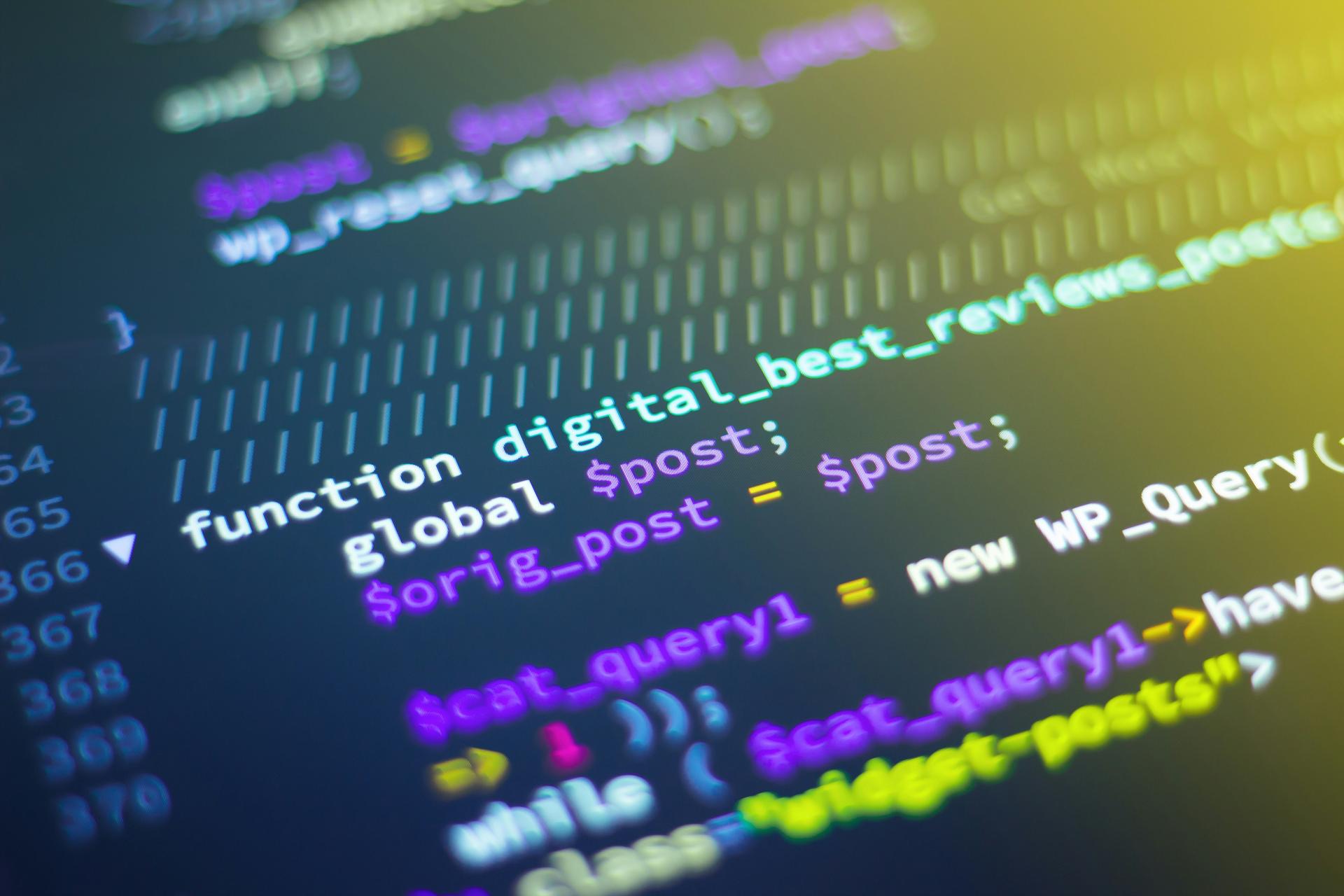 Lines of colourful code on a dark computer screen, evoking cybercrime and online identity fraud.