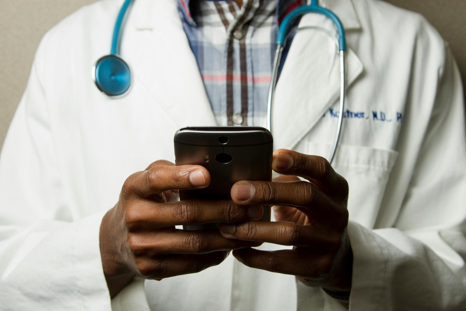 A doctor in a white coat with a stethoscope around the neck, representing physicians who train at home and build careers abroad.