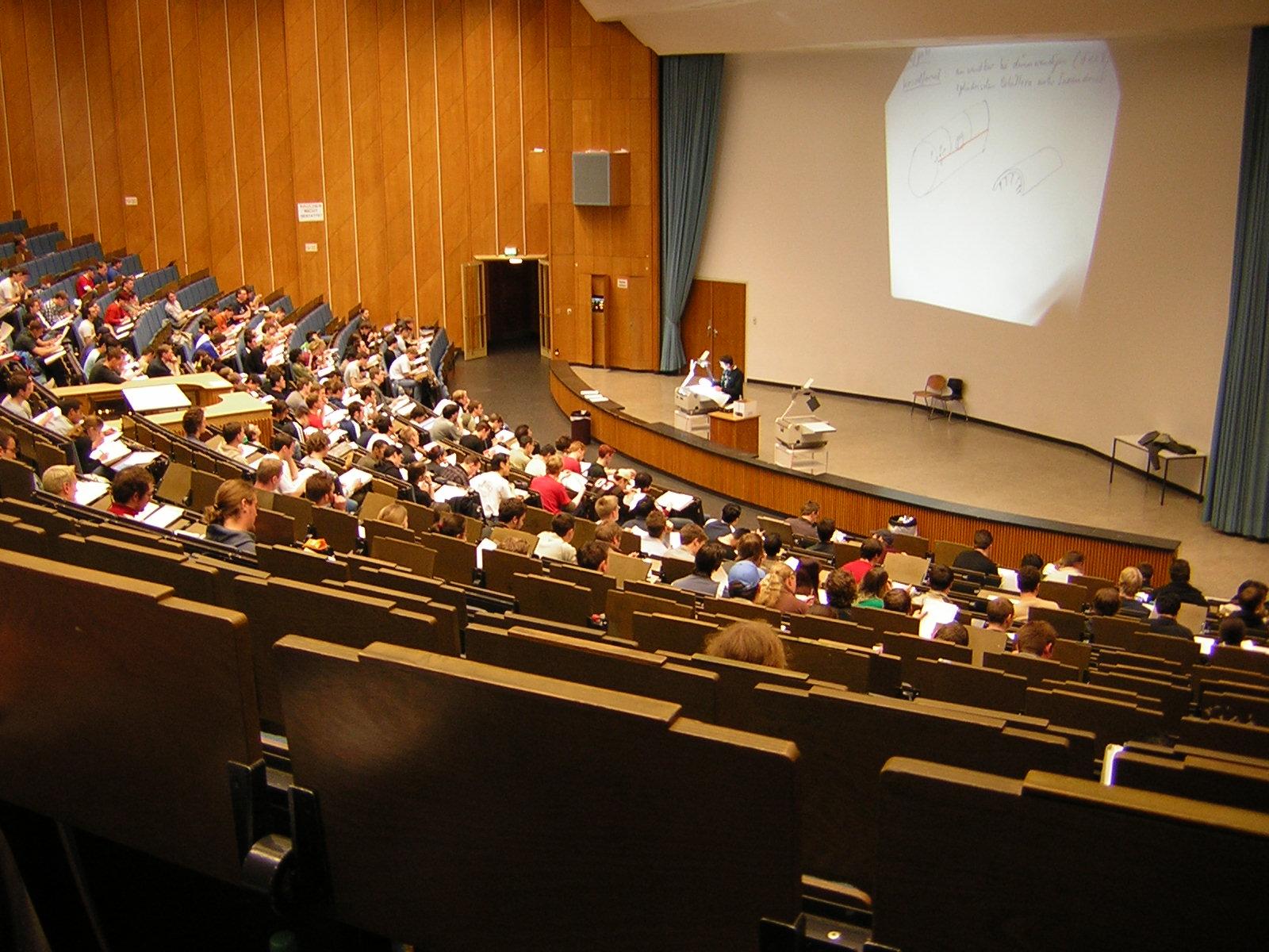 Students fill a lecture hall at RWTH Aachen University in Germany as a professor teaches at the front.