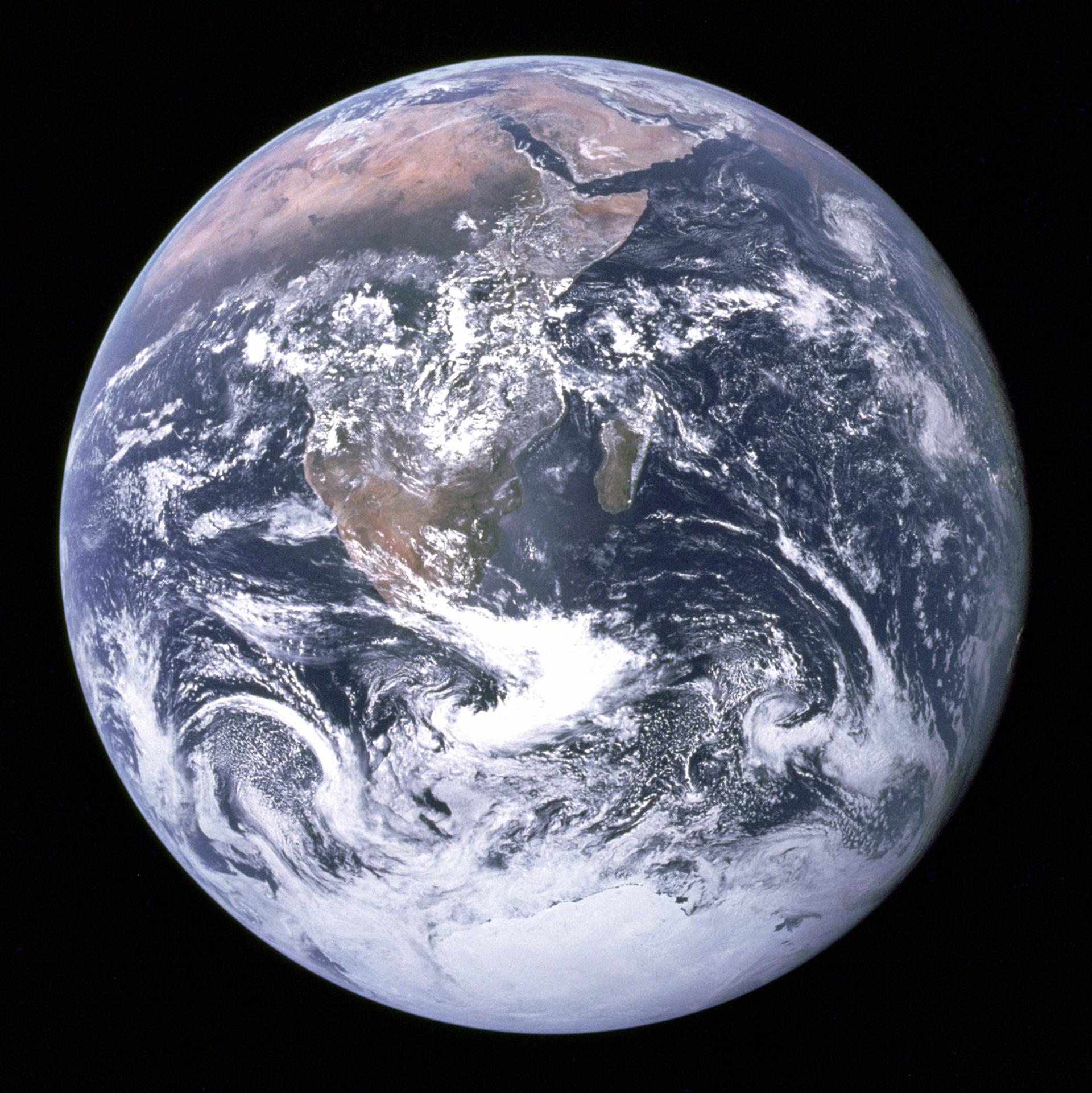 The planet Earth photographed from space, its thin blue atmosphere visible against the dark of space.