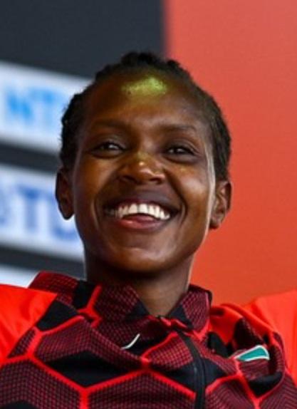 Faith Kipyegon running on the track in Kenyan colours during a championship race