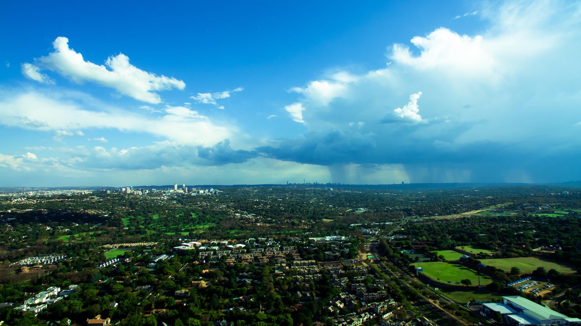 Aerial view of central Johannesburg's skyline with downtown skyscrapers under a partly cloudy sky