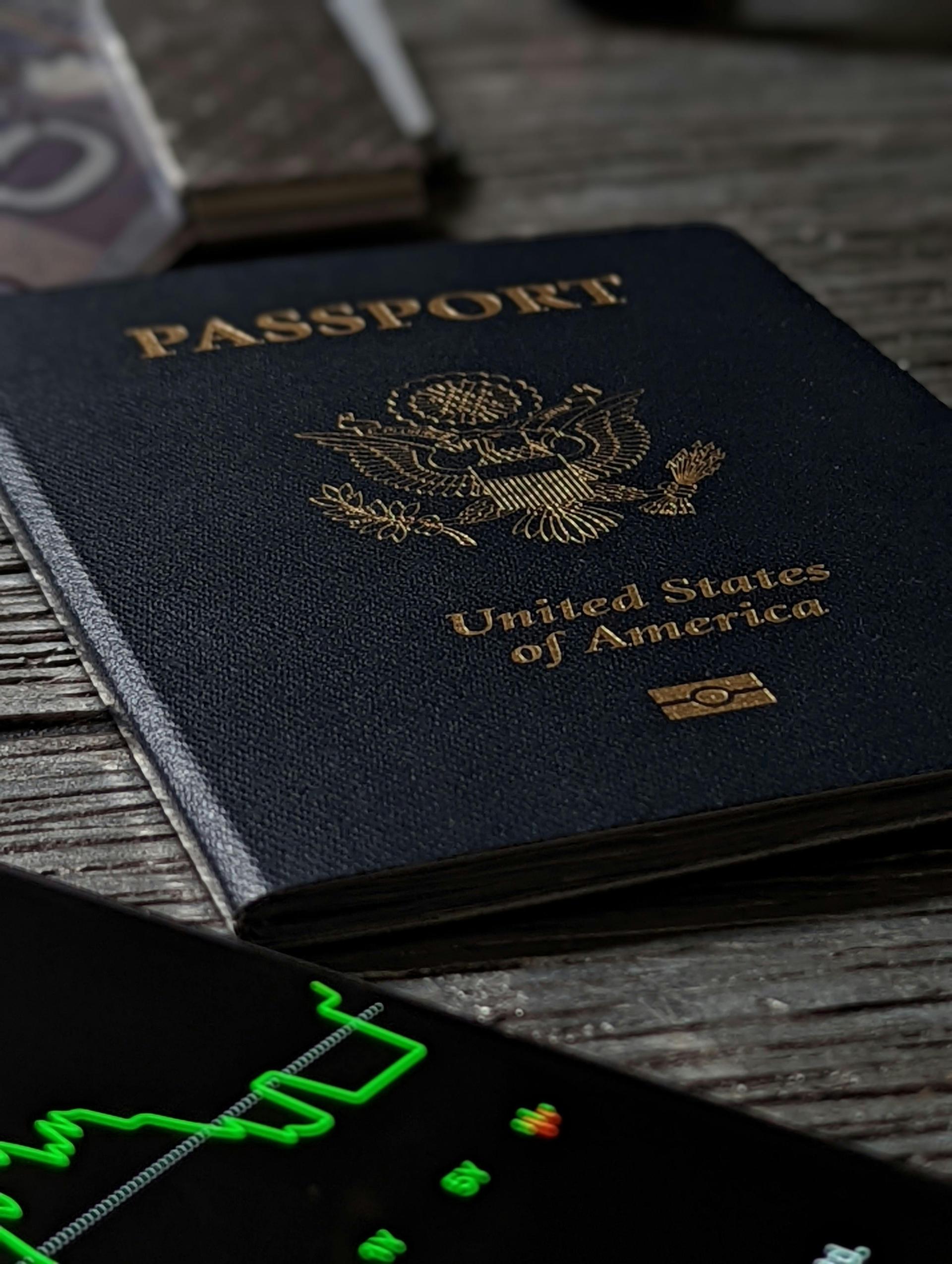 A close-up of a United States passport resting on a wooden table, representing pathways to permanent residency for foreign-born workers in the country