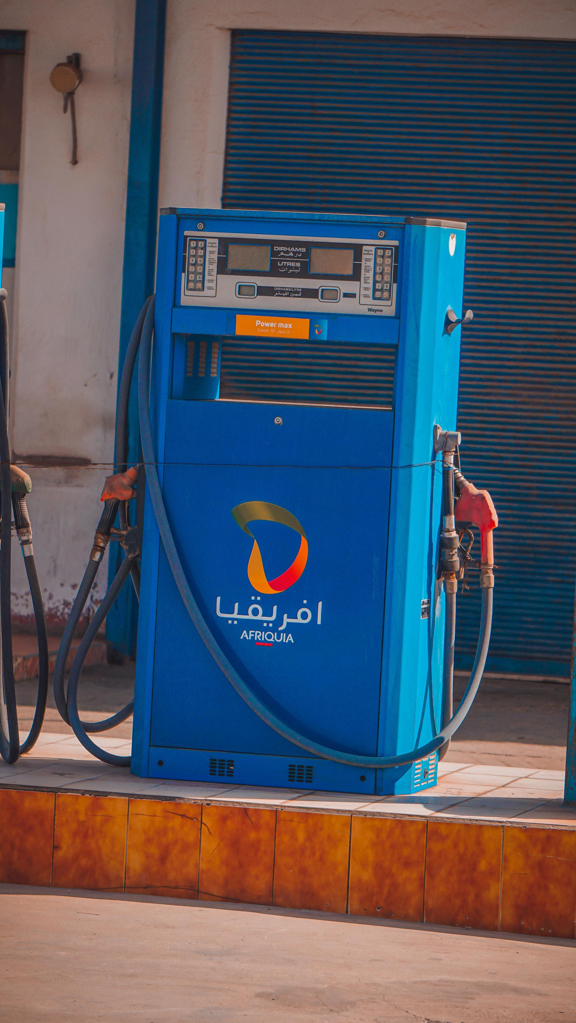 A bright blue fuel pump at a service station, a daily marker of cost of living