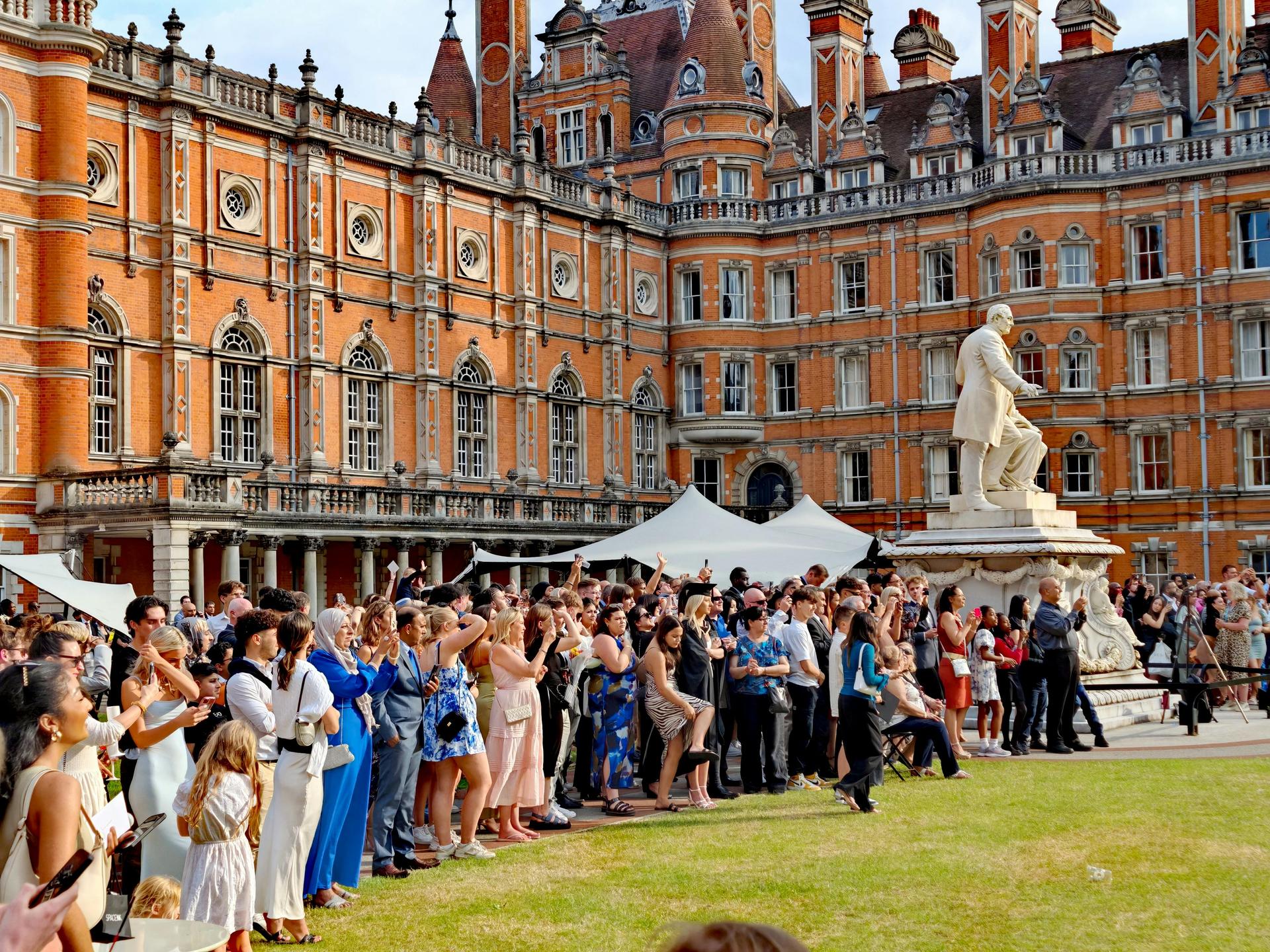 A large crowd gathers at a Royal Holloway, University of London graduation ceremony in Egham, illustrating the UK higher-education sector affected by stricter student-visa rules.
