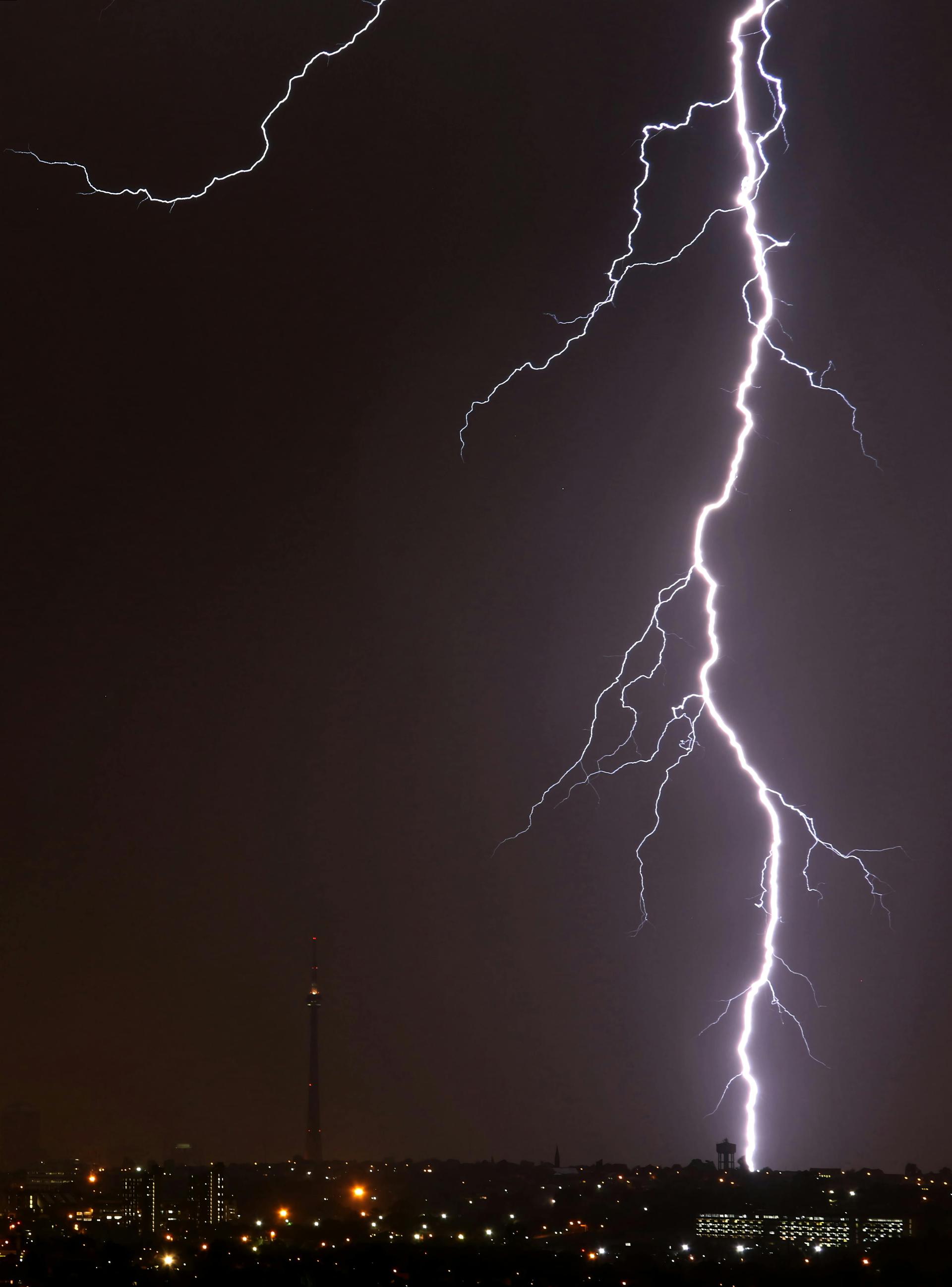 Lightning crackling over Johannesburg's downtown skyline at night, the South African city where many Kenyan diaspora professionals and traders live and work.