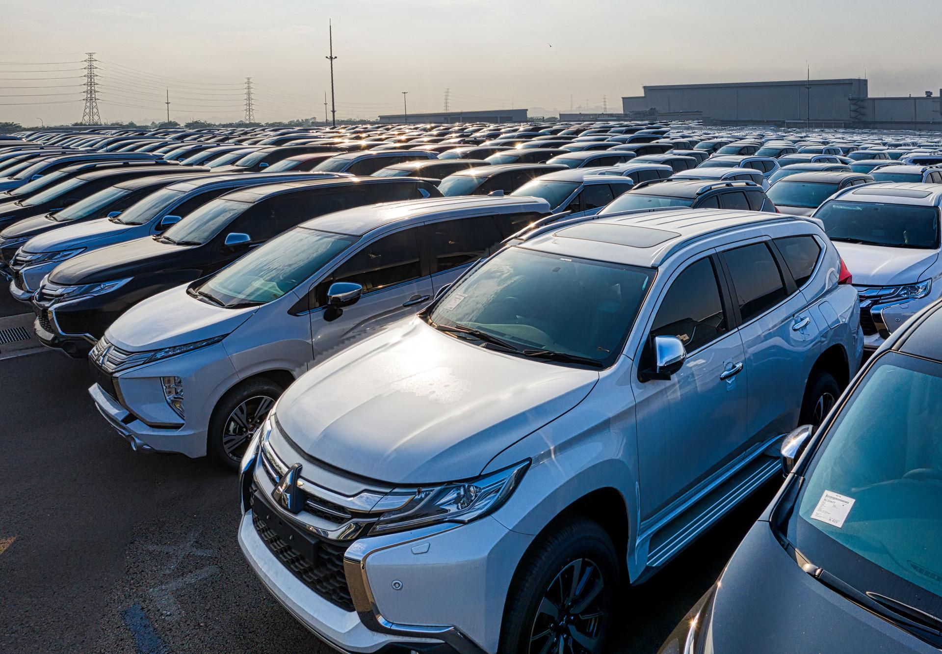 Rows of newly manufactured cars lined up at an automotive production and assembly facility