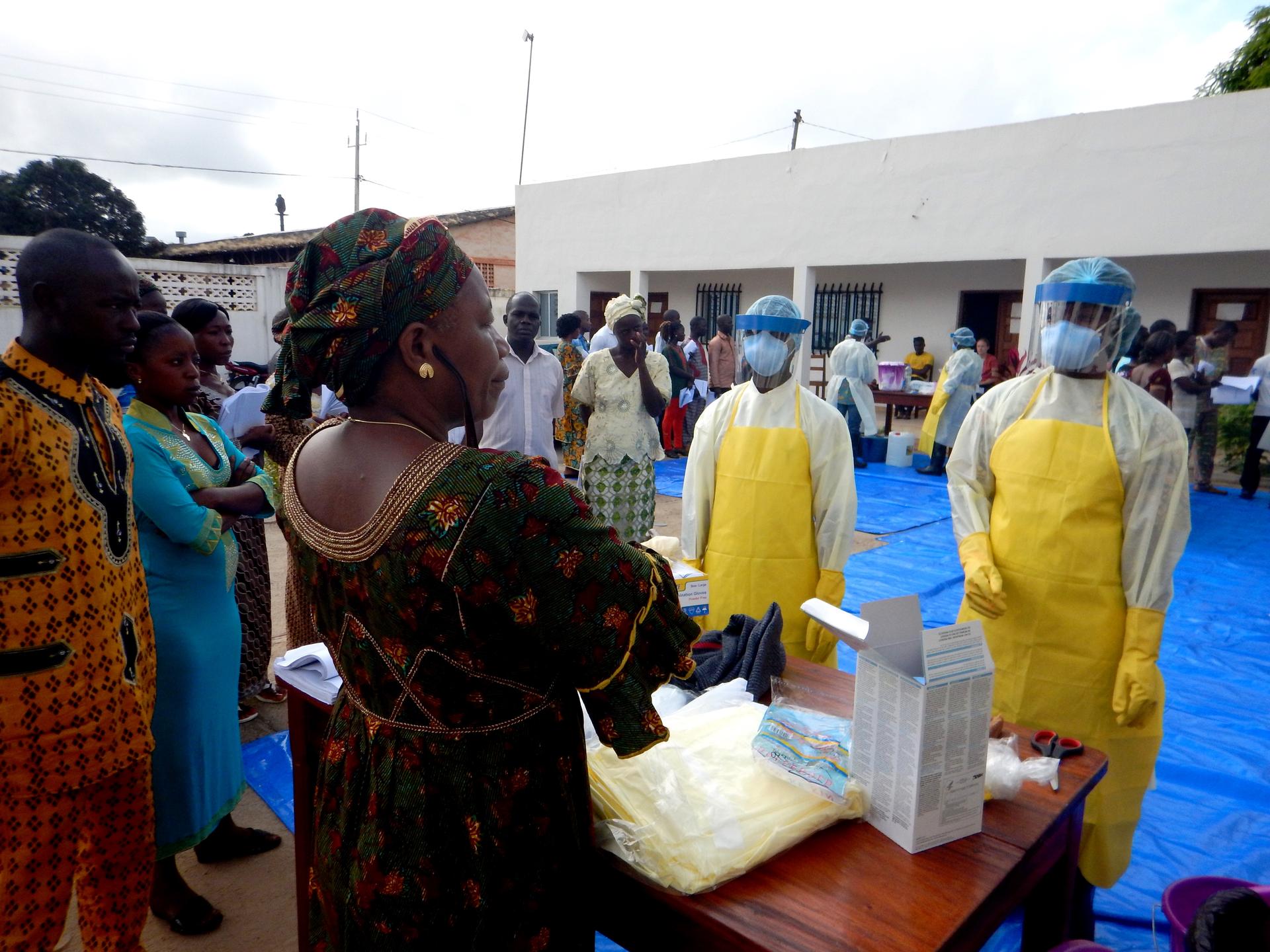 Healthcare workers in full personal protective equipment at an Ebola treatment site during a West Africa outbreak response