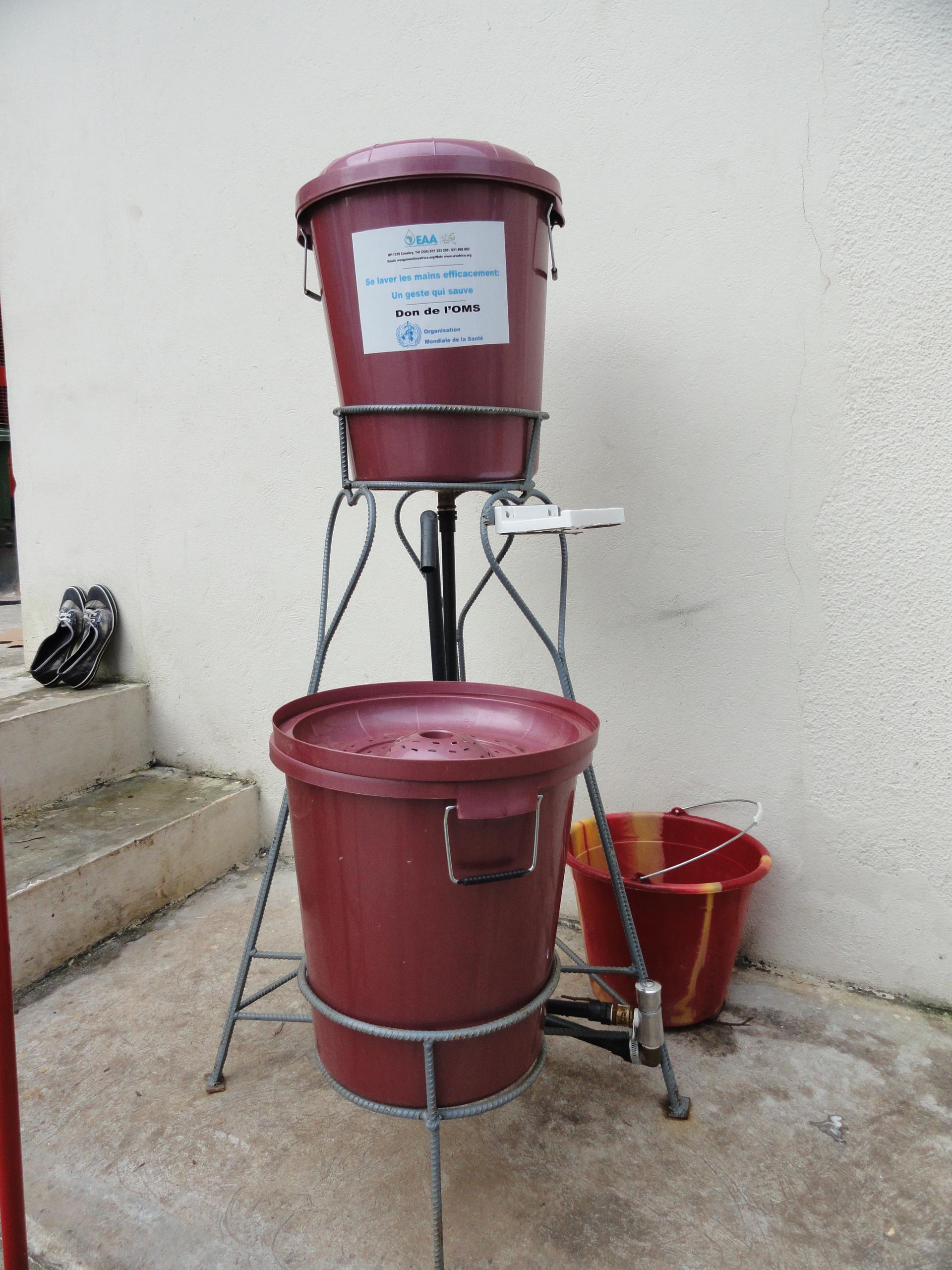 A community handwashing station with water containers and soap, a frontline measure for preventing Ebola transmission.