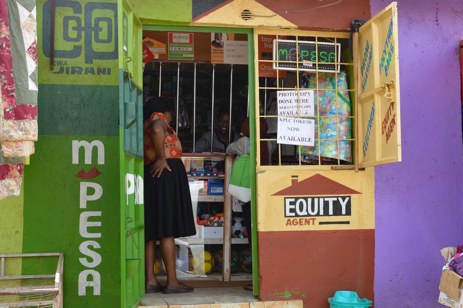 A mobile money and bank agent kiosk on a busy street in Nairobi, Kenya, where families collect cash sent from relatives abroad.