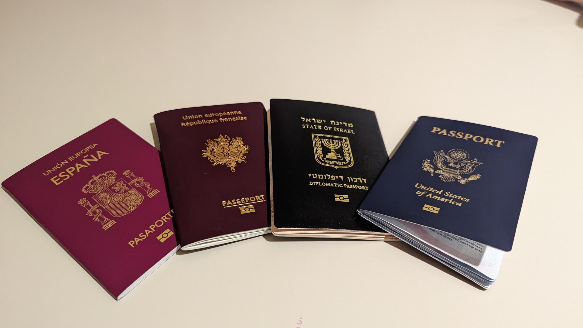 A handful of national passports from different countries fanned out on a flat surface