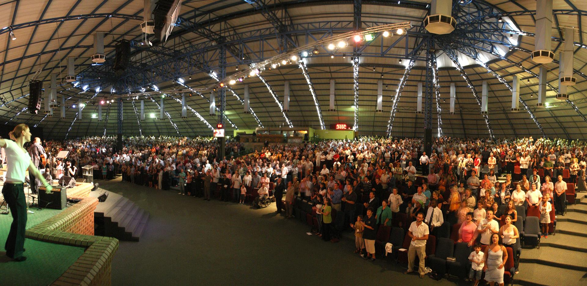 Worshippers raise their hands during a Pentecostal church service in Africa, reflecting the continent's living Christian traditions.