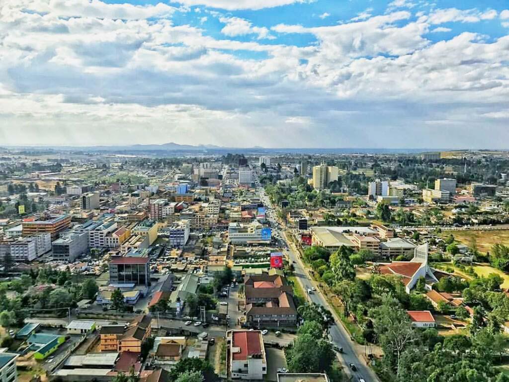 The skyline of Eldoret, Kenya, viewed facing west from Mups Plaza, with low-rise buildings under a wide sky.