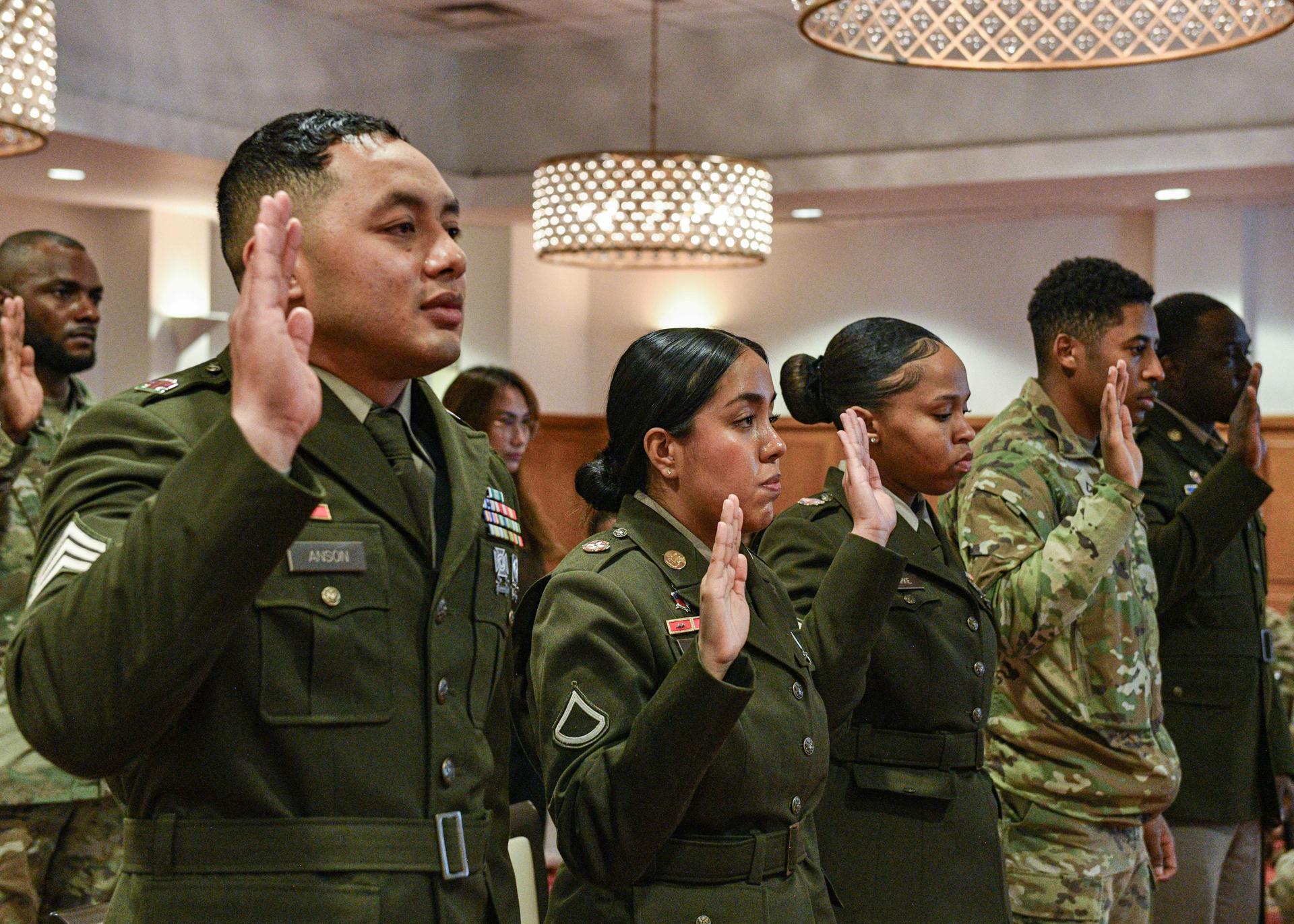 Service members and new citizens recite the oath of allegiance during a U.S. Army naturalization ceremony.