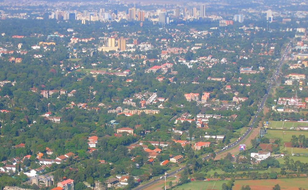 Aerial view of Nairobi showing apartment blocks, office towers and residential neighbourhoods under a hazy sky