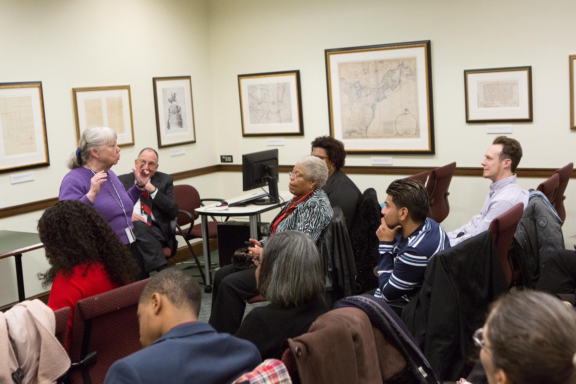 New U.S. citizens hold small American flags and raise their hands to take the oath of allegiance at a naturalization ceremony.