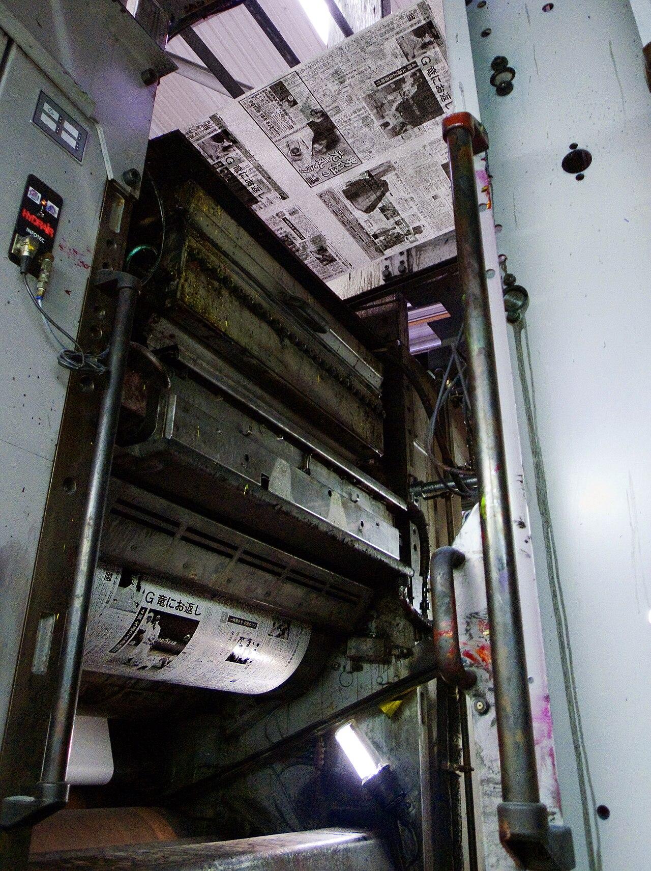 A web-fed offset printing press runs newspaper pages, illustrating a story about a shuttered East African newspaper.