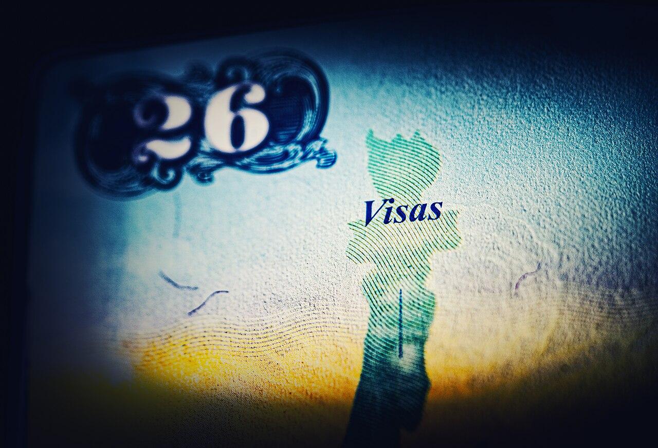 Pages of a United States passport filled with international entry and exit visa stamps and stickers