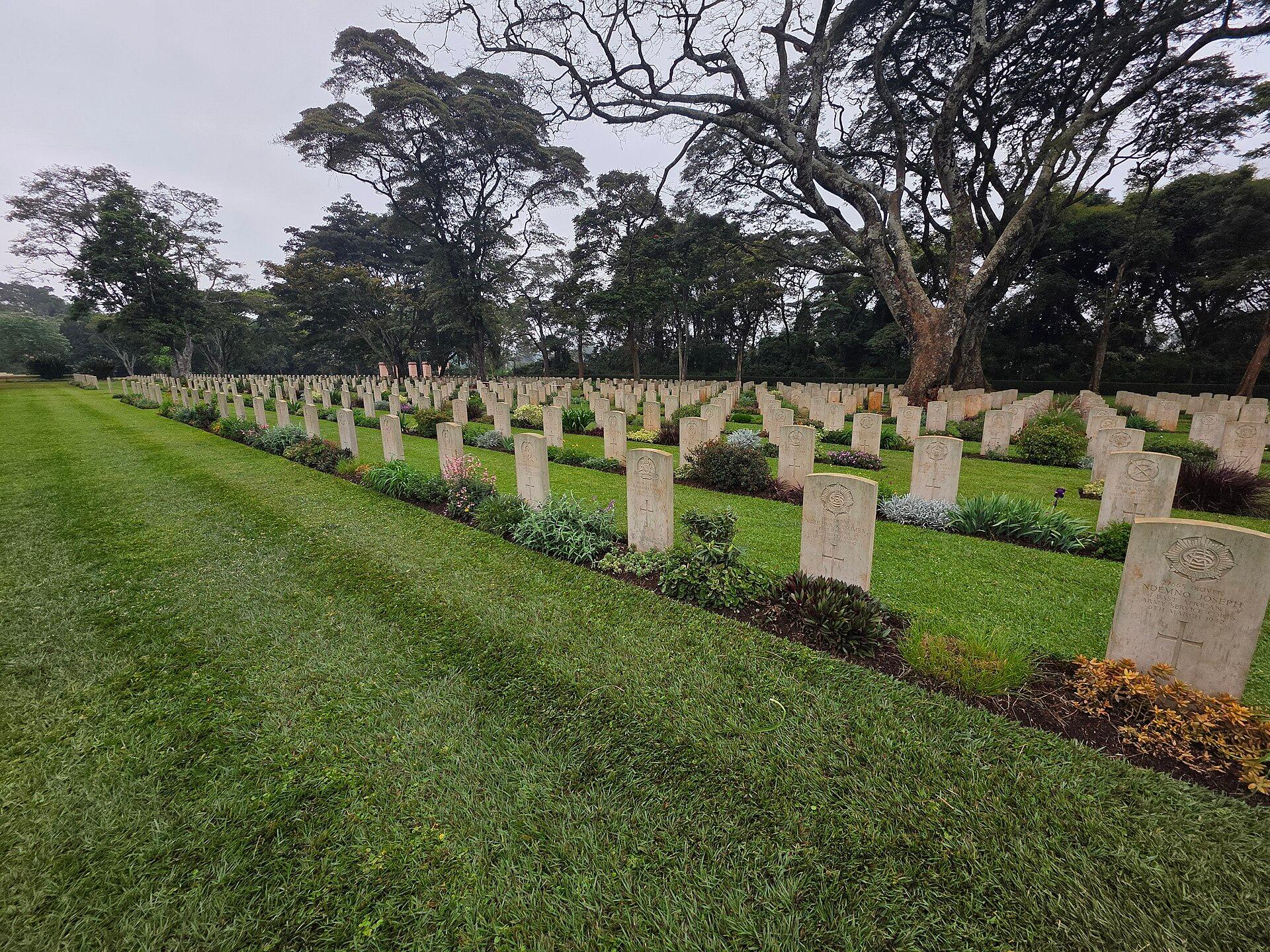 Rows of white Commonwealth war graves headstones on neat green lawns at a Commonwealth War Graves Commission cemetery in Kenya