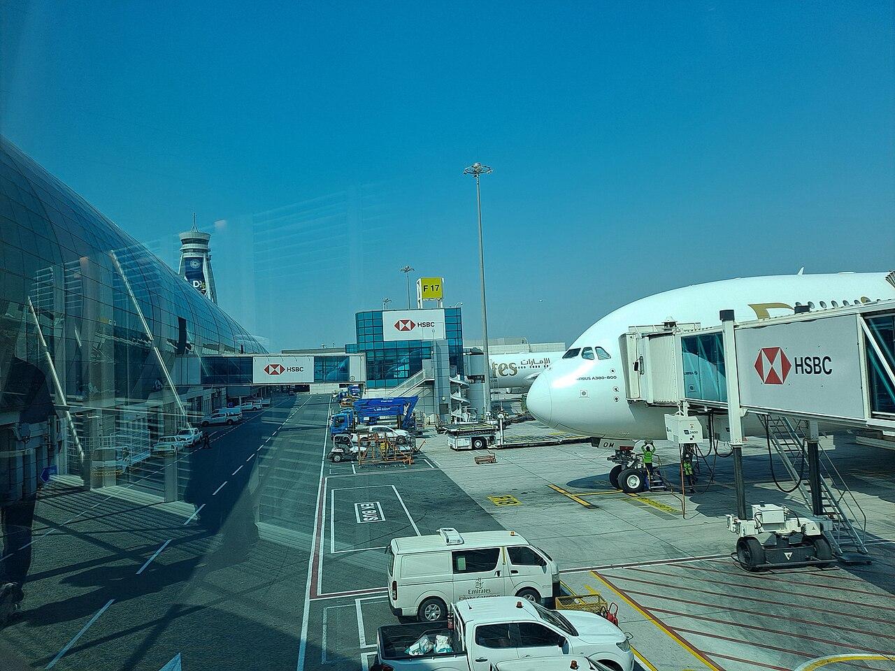 Travellers walk through the bright concourse of Dubai International Airport Terminal 3, a major Gulf transit point for migrant workers.