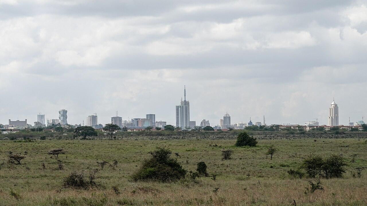 Nairobi city skyline rising beyond the savannah grasslands of Nairobi National Park in Kenya
