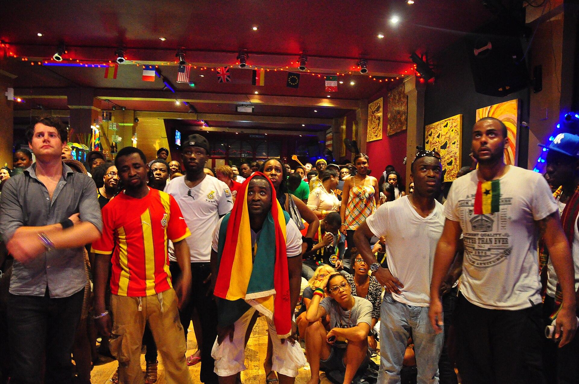 Ghana football supporters in national colours waving flags and celebrating at a FIFA World Cup match