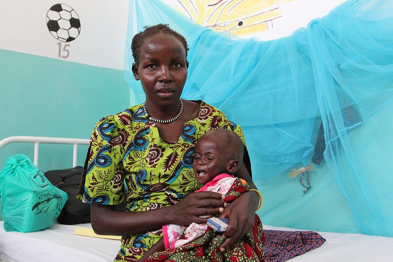 A Kenyan mother holds her child at a hospital in Lodwar, Kenya, as families face rising out-of-pocket medical costs.
