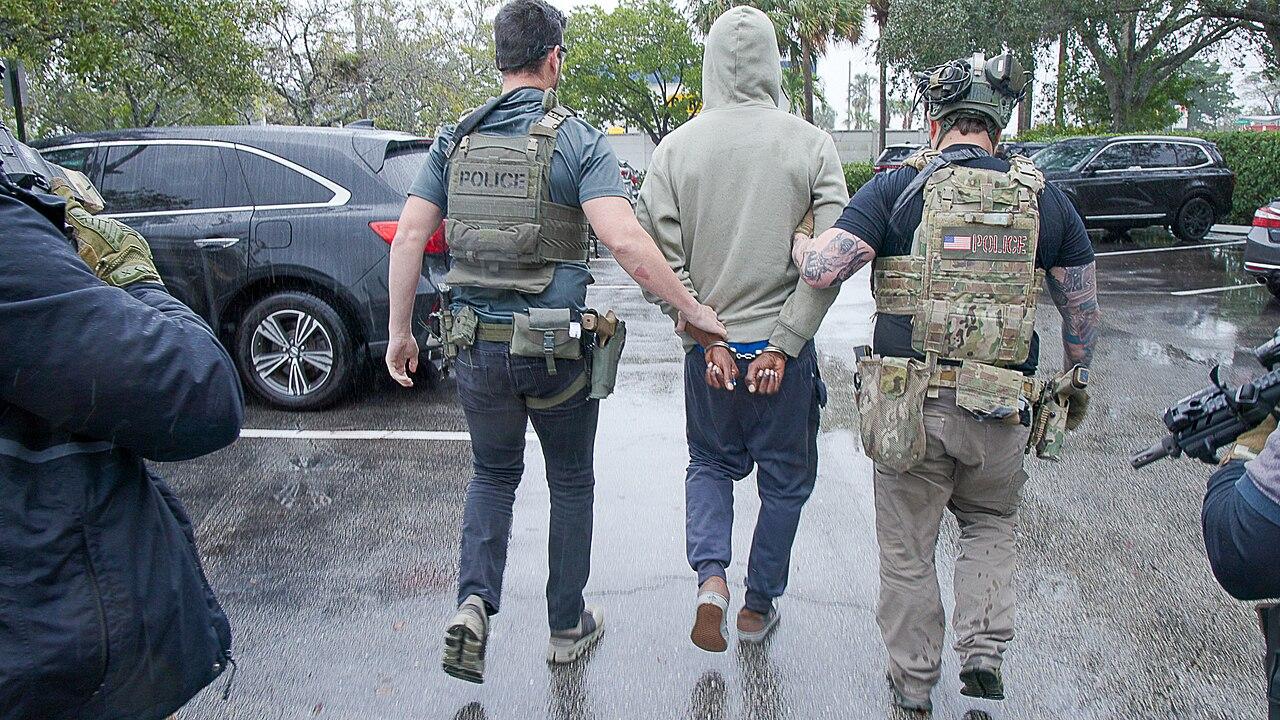 ICE Enforcement and Removal Operations officers in tactical vests during a federal immigration enforcement operation