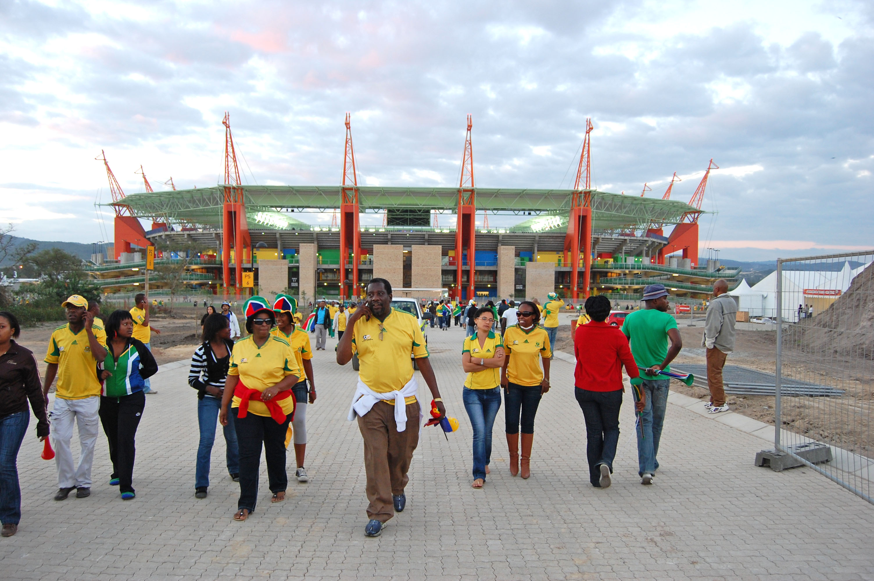 A dense crowd of football fans streaming out of a packed stadium after a match.