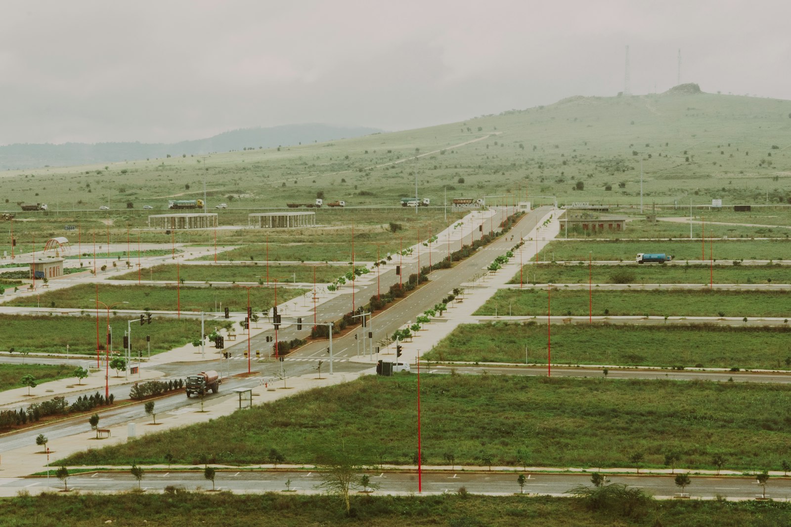 Newly subdivided plots of land carved out of a grassy green area, with paths dividing each parcel from above.