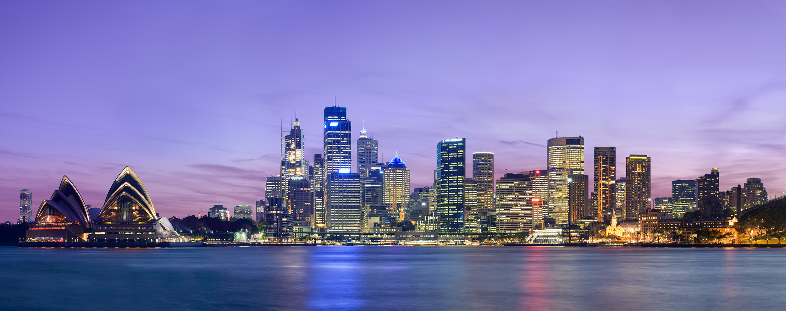 Panoramic view of the Sydney skyline at dusk across Sydney Harbour, where a Kenyan diaspora community is now mobilising for accountability over a young woman's death.