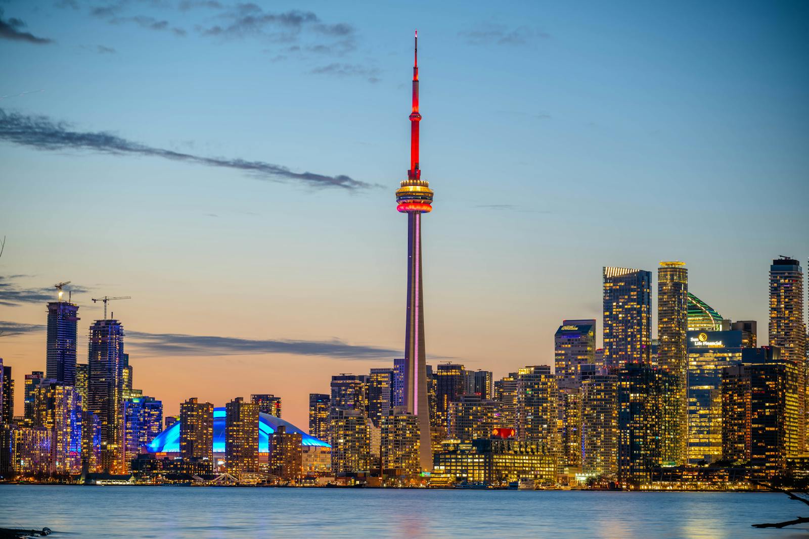Toronto skyline at sunset showing the CN Tower and downtown towers reflected over Lake Ontario, a destination city for Kenyan Express Entry applicants