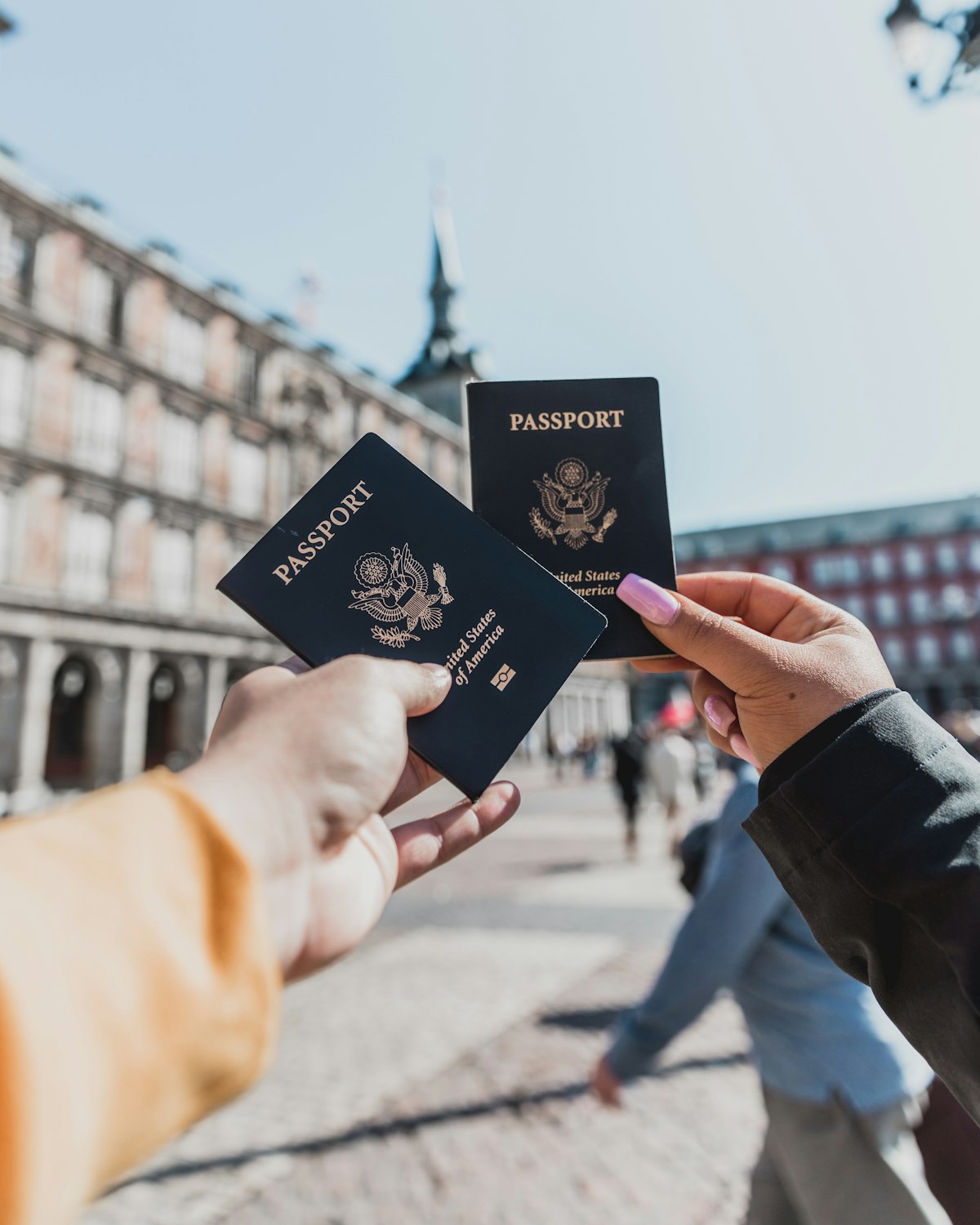 A traveller holds open passports over a wooden table, the kind of small ritual that often begins a long bureaucratic journey for Kenyans abroad.