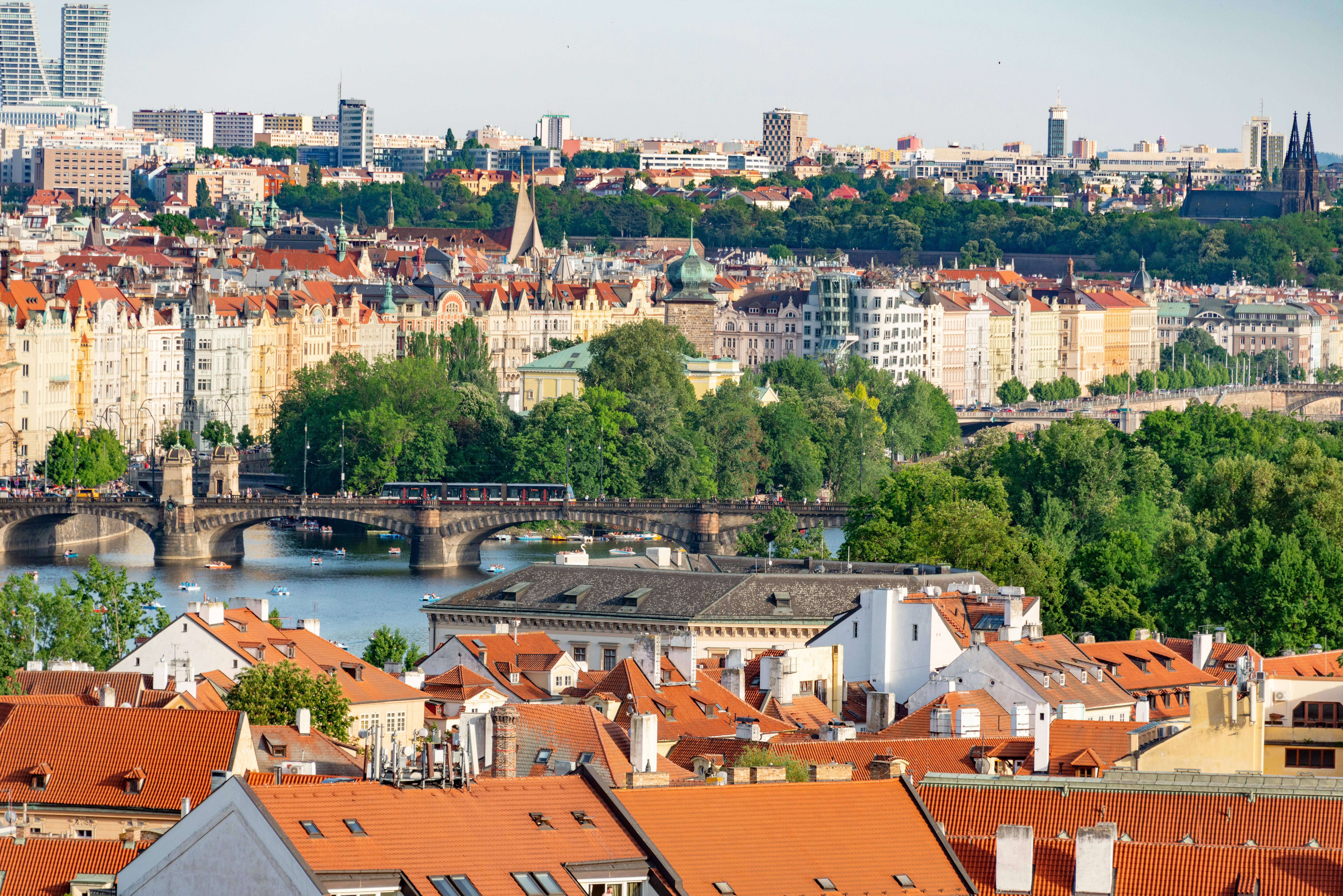 Aerial view of historic Prague with bridges crossing the Vltava River and red-roofed Old Town buildings