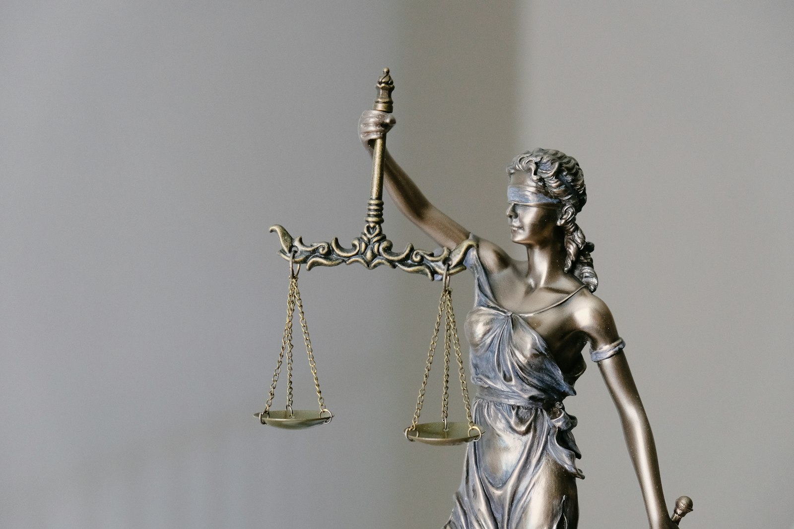 Bronze statue of Lady Justice holding scales and a sword, evoking the UK Crown Court system in which the Reading murder case is being heard.